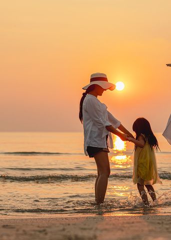 Familie am Strand bei Sonnenuntergang