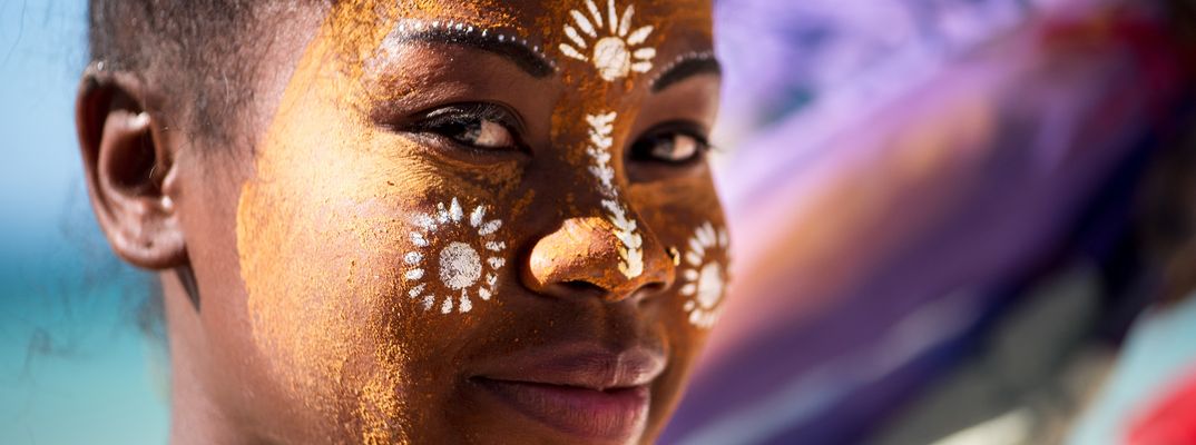 Frau in Madagaskar mit traditioneller Zeichnung im Gesicht