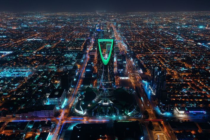 Luftaufnahme von Riad bei Nacht mit leuchtender Skyline und Straßennetz