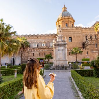Frau vor der Kathedrale von Palermo mit Palmen und Platz