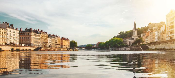 Fluss Rhône mit Stadtansicht und historischen Gebäuden bei ruhigem Licht