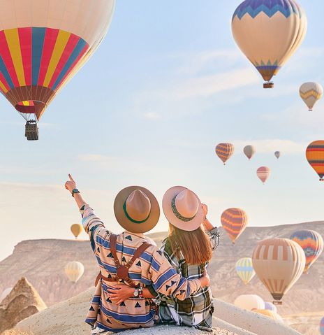 Paar auf Felsen mit Heißluftballons