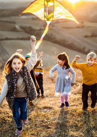 Kinder beim Drachensteigen im Herbst