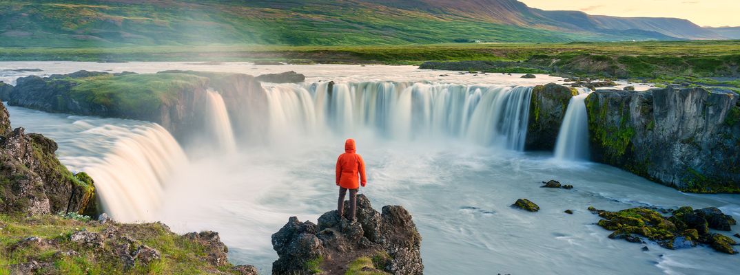 Mann vor Wasserfall auf Island