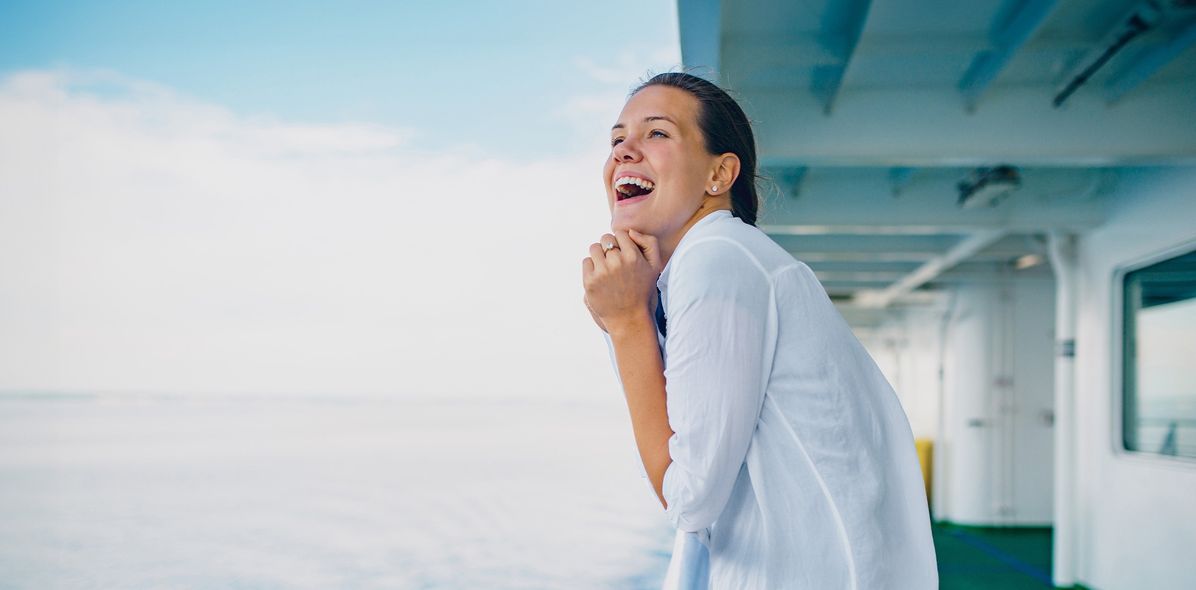 Fröhliche Frau auf Kreuzfahrtschiff