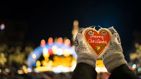 Hand mit Lebkuchenherz "Merry Christmas"