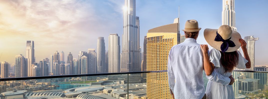 Reisepaar genießt Aussicht auf Dubai Skyline von einer Terasse aus