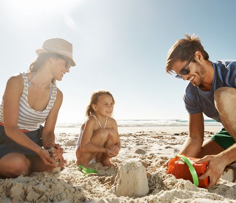 Familie am Strand mit Sandburg