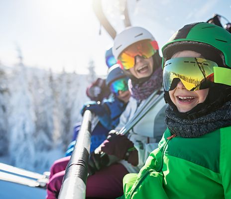 Familie auf Lift mit Schnee