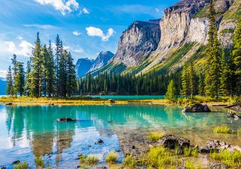 Türkisfarbener See im Jasper Nationalpark mit Felsen, Wald und Bergen