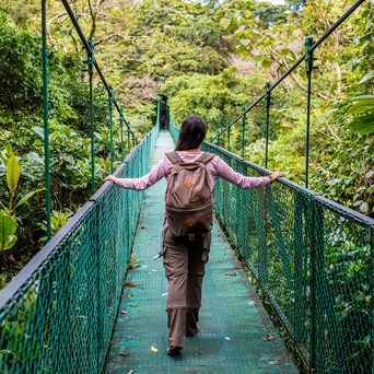 Reisende überquert eine Hängebrücke im Nebelwald von Monteverde