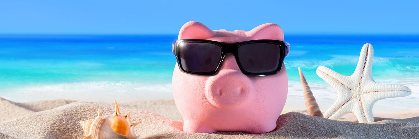 Sparschwein mit Sonnenbrille am Strand