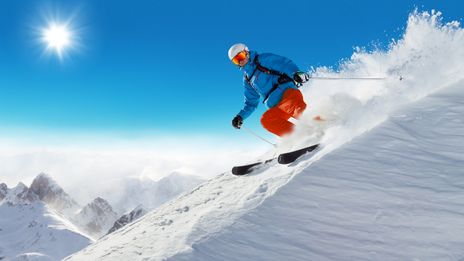 Mann fährt Ski auf einer Piste