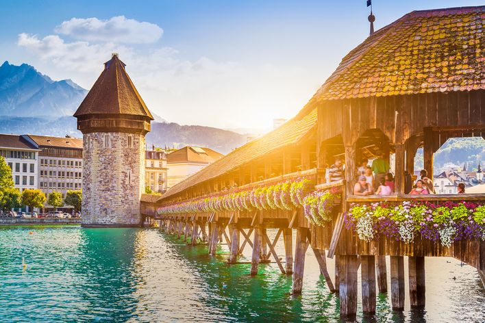 Die historische Kapellbrücke in Luzern führt bei warmem Abendlicht über die türkisfarbene Reuss.
