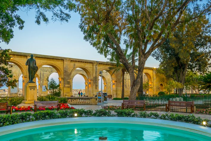 Die Upper Barrakka Gardens mit Brunnen und Arkaden in der Abenddämmerung in Valletta, Malta
