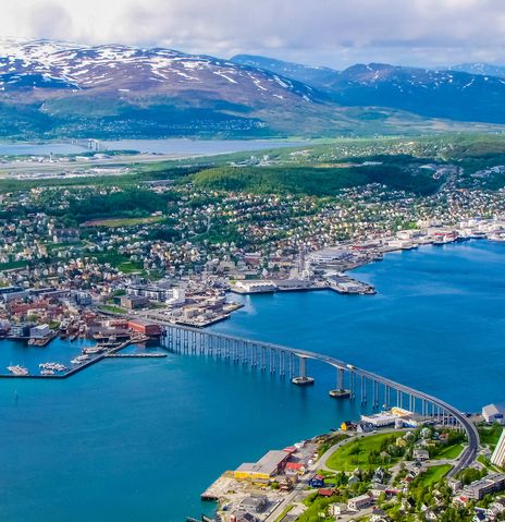 Blick auf Tromsø mit Brücke, Hafen und umliegenden Bergen