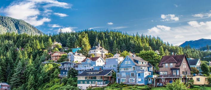 Häuser von Ketchikan an bewaldetem Hang an der Küste Alaskas