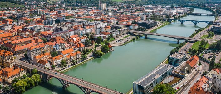 Panoramablick von Maribor mit Fluss, Brücken und dichter Altstadtbebauung
