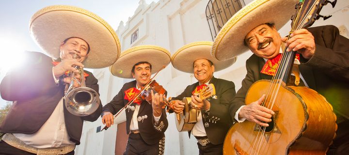 Mariachi-Musiker mit traditionellen Instrumenten und Sombreros beim Auftritt in Mexiko.