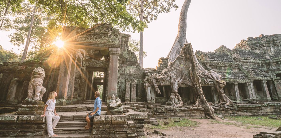 Paar sitzt auf Treppen in Angkor Wat und bestaunt die Anlage