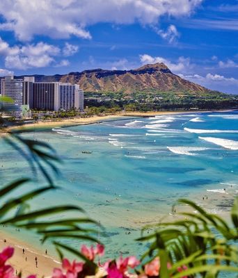 Waikiki Beach in Honolulu mit türkisfarbenem Meer und dem Diamond Head im Hintergrund