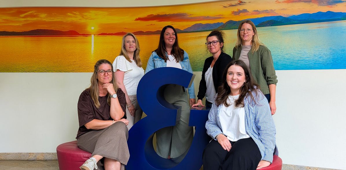 Die Kollegen des Website Teams vor dem Superzeichen von Berge & Meer