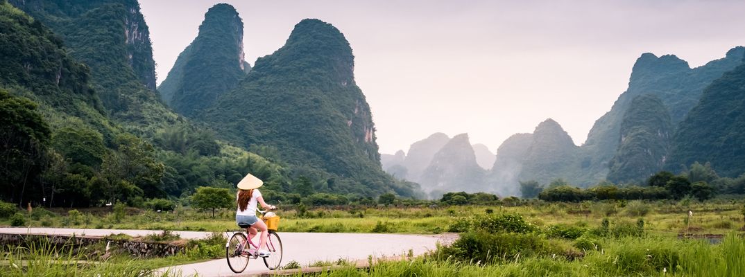 Radfahrerin in einer typischen chinesischen Landschaft