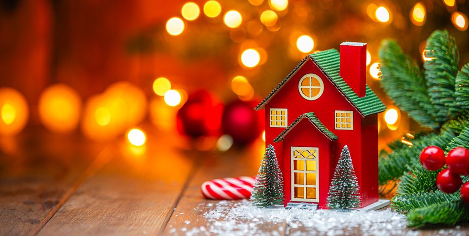 Ein kleines rotes Spielhäuschen vor dem Weihnachtsbaum in festlicher Stimmung