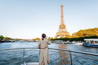 Frau auf einem Flusskreuzfahrtschiff fotografiert den Eifelturm in Paris
