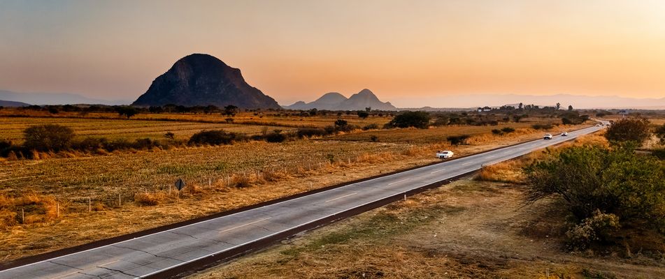 Landstraße durch die weite Landschaft Mexikos bei Sonnenuntergang