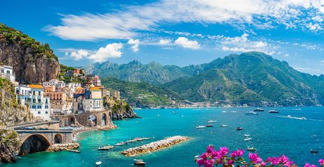 Panoramablick auf ein buntes Bergdorf am Meer mit Felsen, Bergen und Blumen an der Amalfiküste in Italien