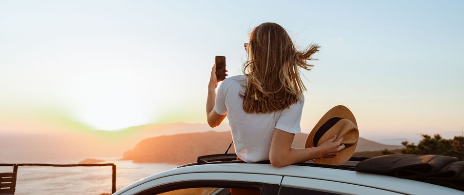 Frau im Auto am Strand