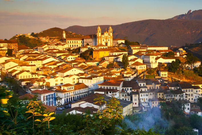 Historische Altstadt von Ouro Preto in Brasilien mit beleuchteten Kolonialbauten und Kirchen in der Abenddämmerung