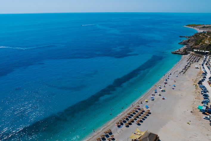 Dhërmi Beach mit weitläufigem Kiesstrand und glasklarem Wasser an der albanischen Küste