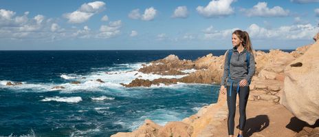 Wanderin an der Küste Sardiniens mit Blick auf das Meer