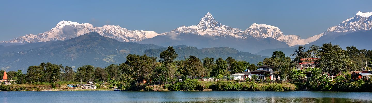 Pokhara am Phewa-See mit Bergen, Stadt und ruhiger Wasseroberfläche