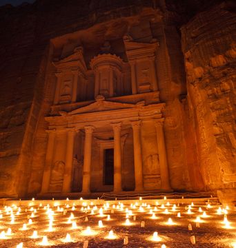 Lichter vor der Felsenstadt Petra in Jordanien in der Nacht