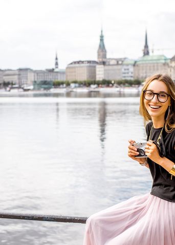 Frau sitzt am Alsterufer mit Blick auf Hamburg