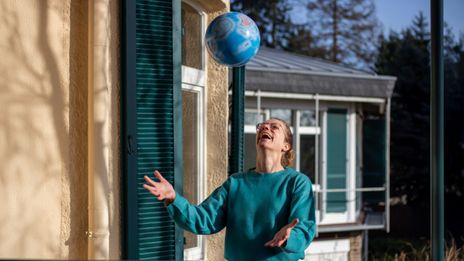 Mitarbeiterin Manuela hat Spaß mit einem Wasserball als Globus