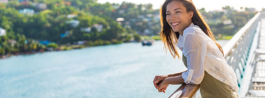 Eine Frau blickt vom Schiff in die vorbeiziehende Landschaft