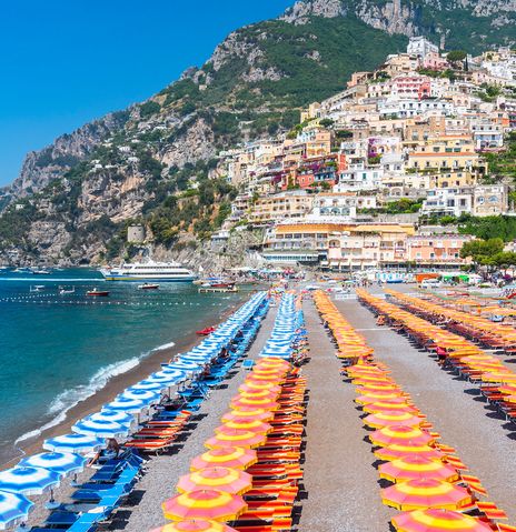 Strand von Positano mit bunten Sonnenschirmen und Amalfiküste