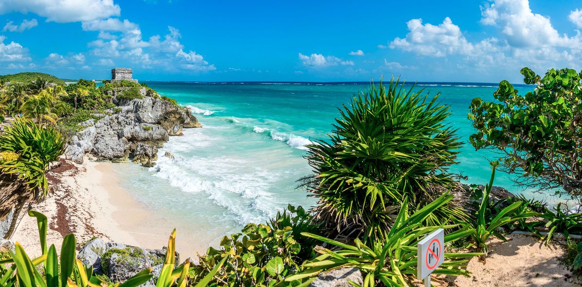 Blick auf Maya Ruinen und Strand mit Palmen
