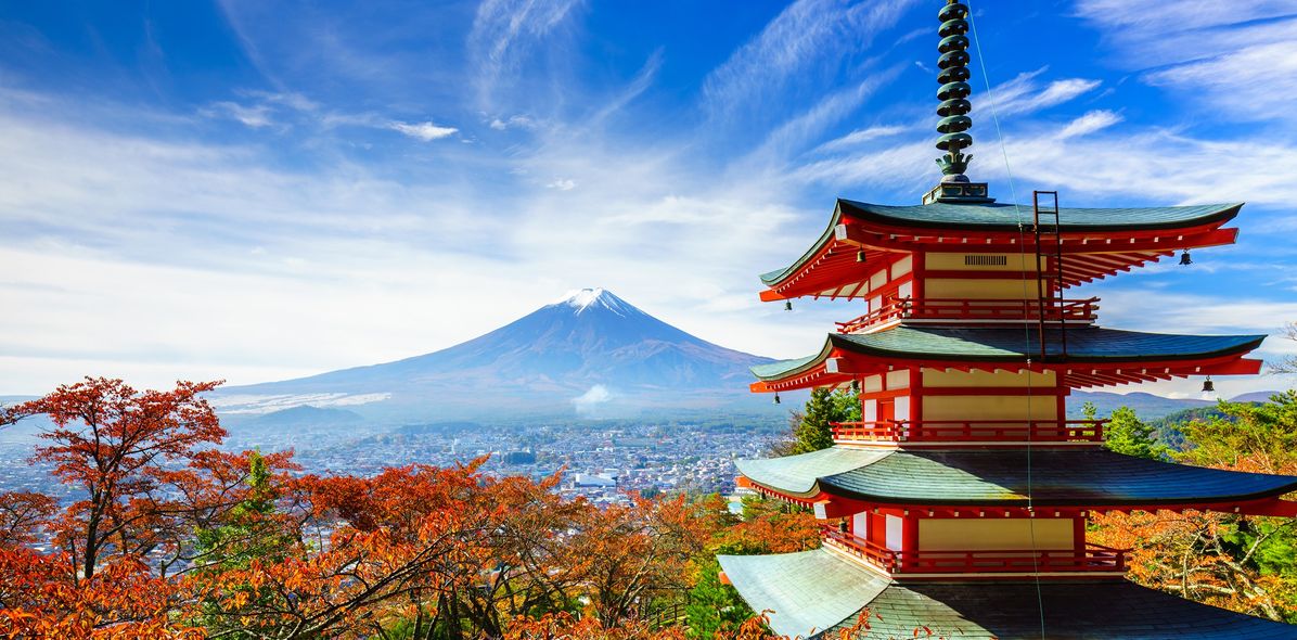 Blick an einer klassischen japanischen Pagode entlang auf den Mount Fuji in Japan mit wolkenbehangenem Himmel