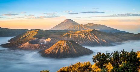 Blick auf den Vulkan Mount Bromo mit Nebelmeer und Kraterlandschaft bei Sonnenaufgang auf Java, Indonesien