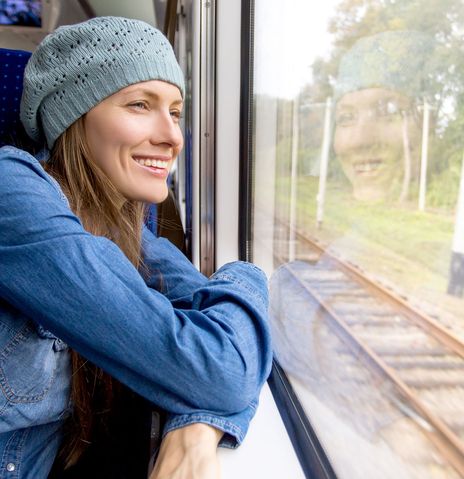 Frau im Zug schaut aus dem Fenster