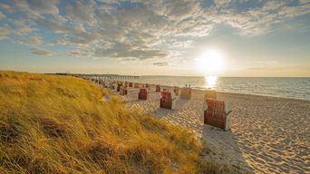 Der Weissenhäuser Strand in Mecklenburg Vorpommern mit Strandkörben während des Sonnenuntergangs