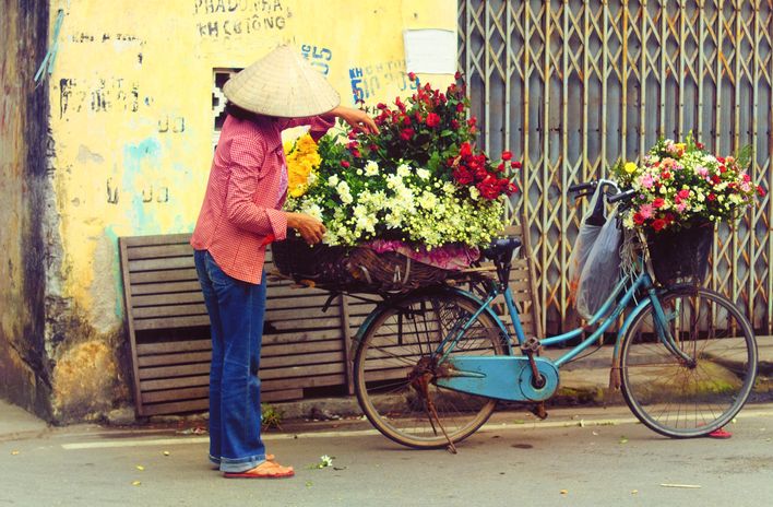 Frau mit Fahrrad in den Straßen von Hanoi in Vietnam