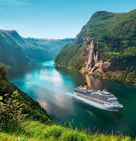 Ein Schiff der Reederei Costa Kreuzfahrten, welches durch einen Fjord fährt