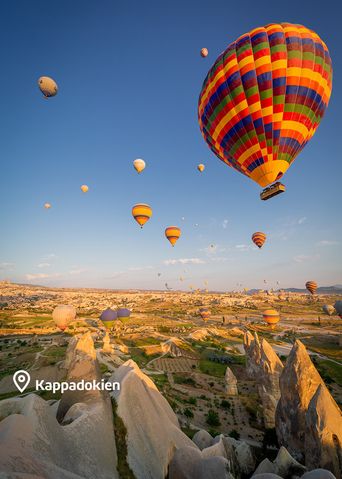 Einzelner Heißluftballon schwebt über einem Tal in Kappadokien
