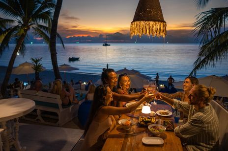 Gruppe bei einem gemeinsamen Abendessen am Strand